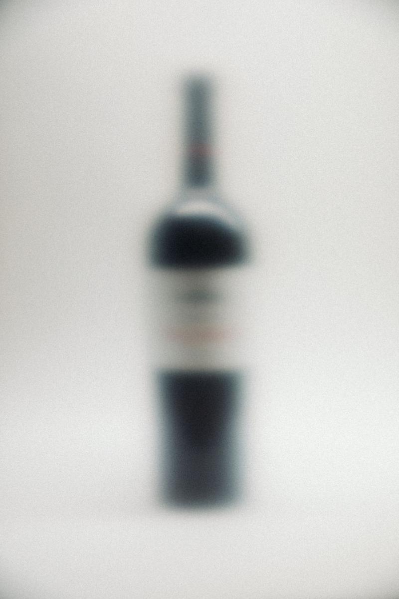 Out of focus bottle of Chateau Clinet against white background