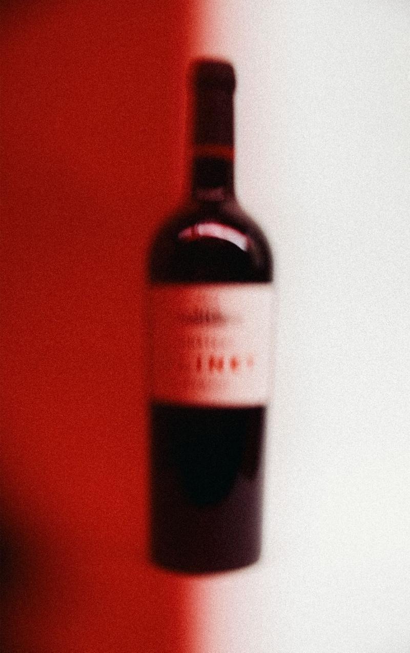 Bottle of chateau clinet half behind red filter, slightly out of focus